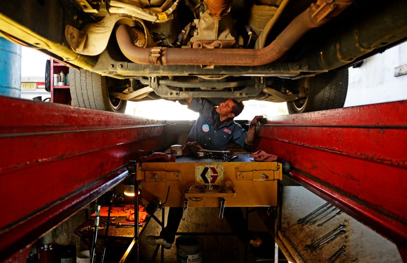 DENVER, CO - NOVEMBER 11: Julio Vergara works on doing and oil change, at a Grease Monkey in east Denver, on a truck owned by active army soldier Luke Goeckner, November 11, 2013. Veterans got a free oil change at many Grease Monkey locations for Veterans Day. (Photo By RJ Sangosti/The Denver Post)